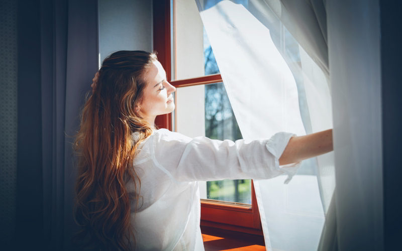Client comfortness between velvet curtains and blinds.